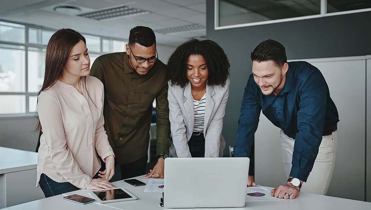“Diverse digital marketing team working on laptops and analytics dashboards in a modern USA office, representing remote and hybrid job trends in 2025.”