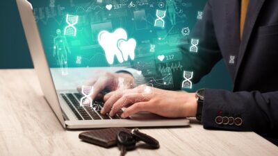 Smiling dentist using laptop for digital marketing strategy in 2025